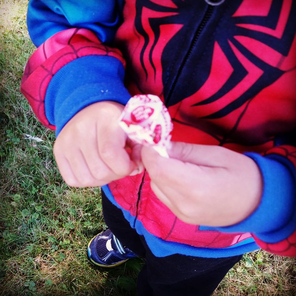 miraclelollypop.jpg Child holding a dum dum lollypos.  You can only see his hands and his body from the waist down.  He is wearing a spiderman jacket.